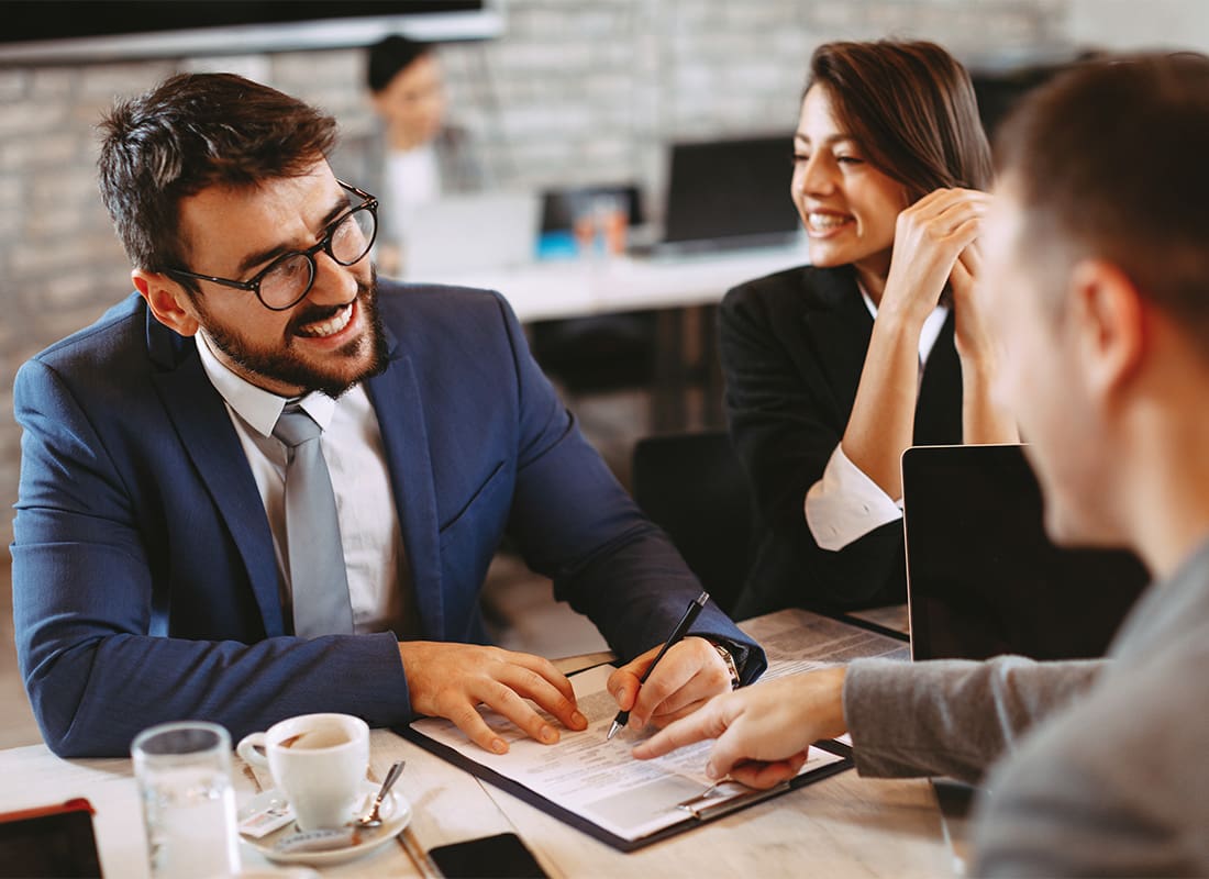 Custom Captive Insurance - Business Couple Signing Documents in Workspace